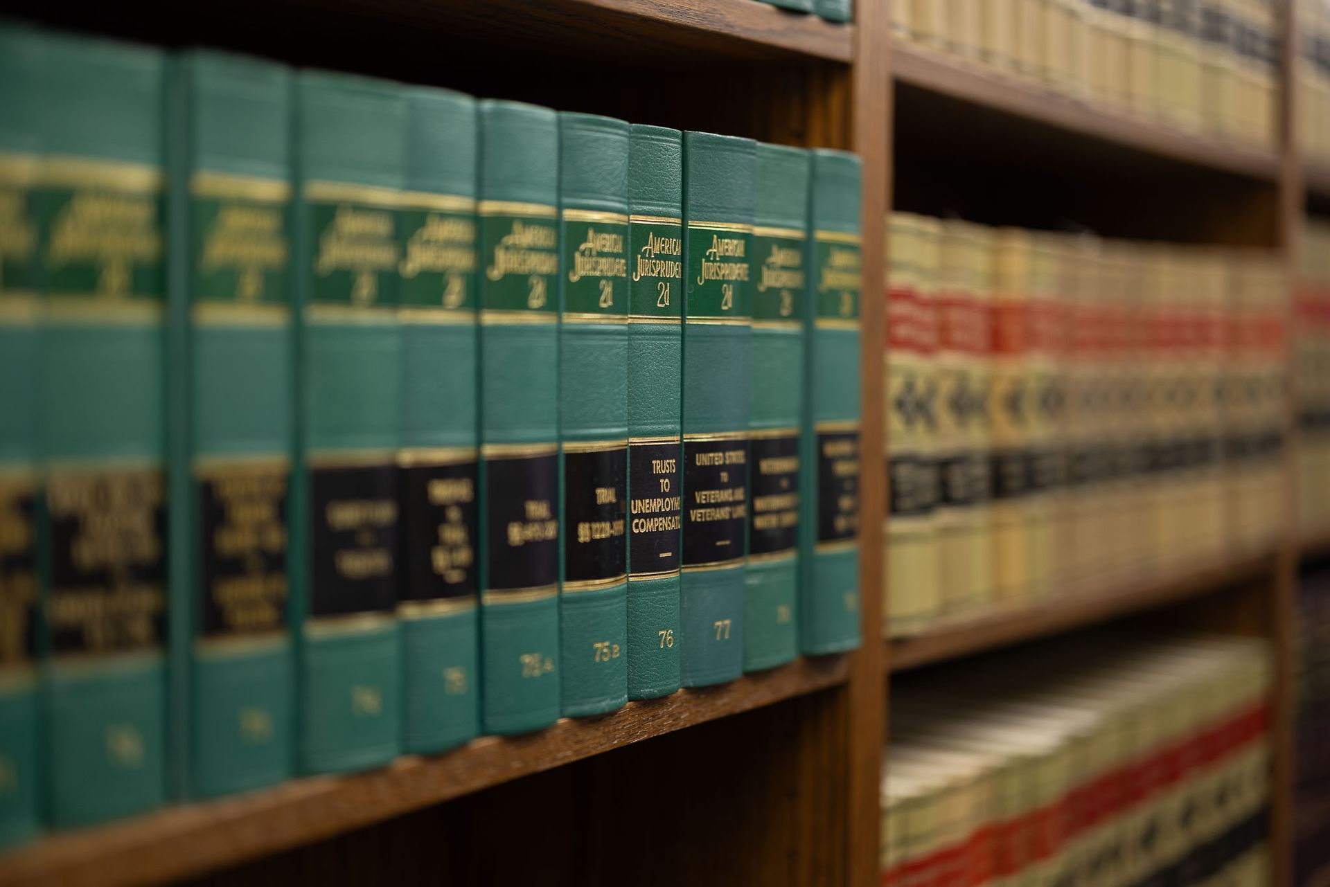 Rows of green and red legal books on wooden shelves in a library