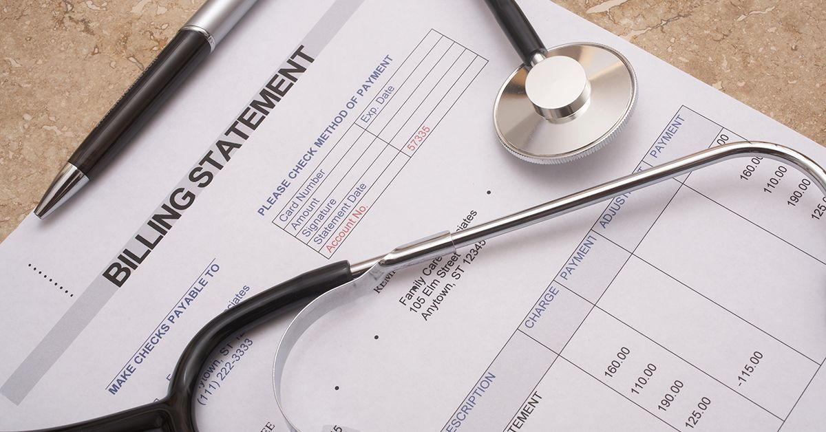 Billing statement with pen and stethoscope on a desk