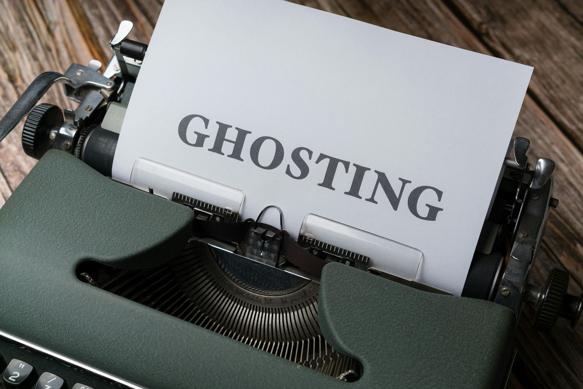 Typewriter with paper reading “GHOSTING” in bold letters