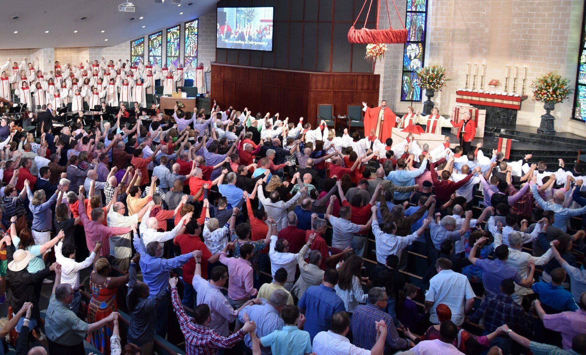 Photo of congregation with arms raised during worship service