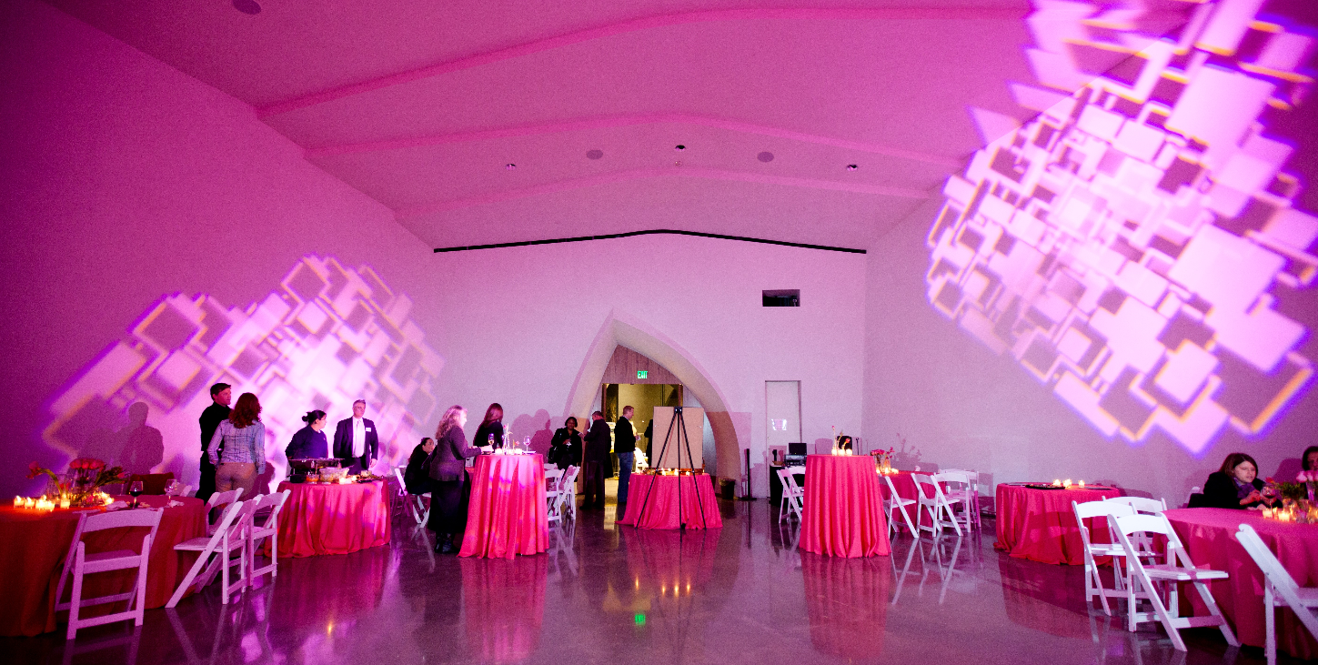 Wedding reception setting in Interfaith Peace Chapel. Pink Tablecloths and lighting effects on the walls