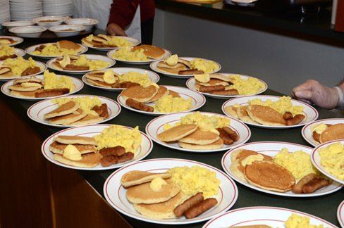 Breakfast at the Cathedral photo. Plates of pancakes and sausage being served.