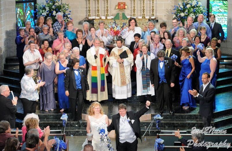 Large wedding party on the chancel as he married couple exits the sanctuary