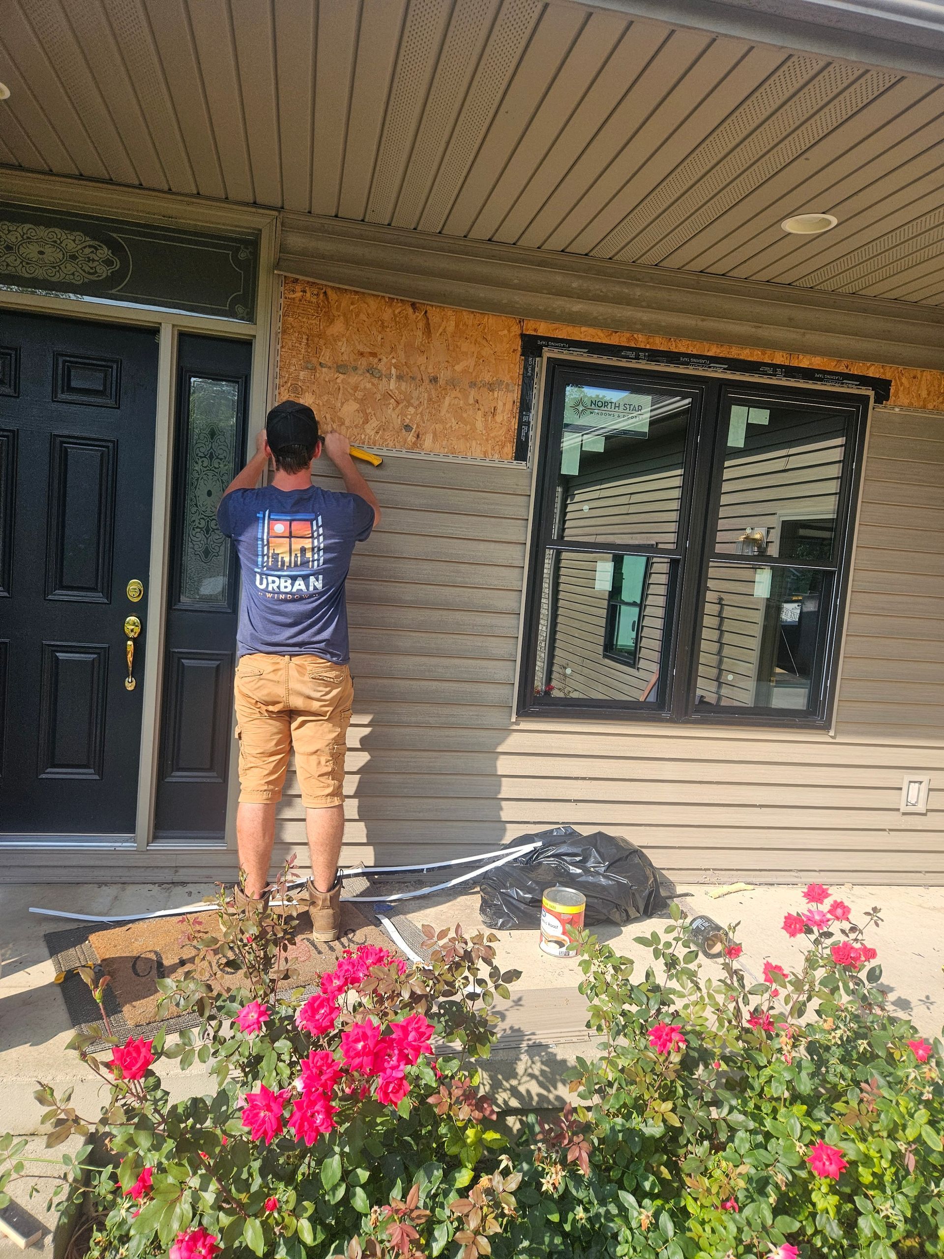 A man is standing in front of a house that is being remodeled.