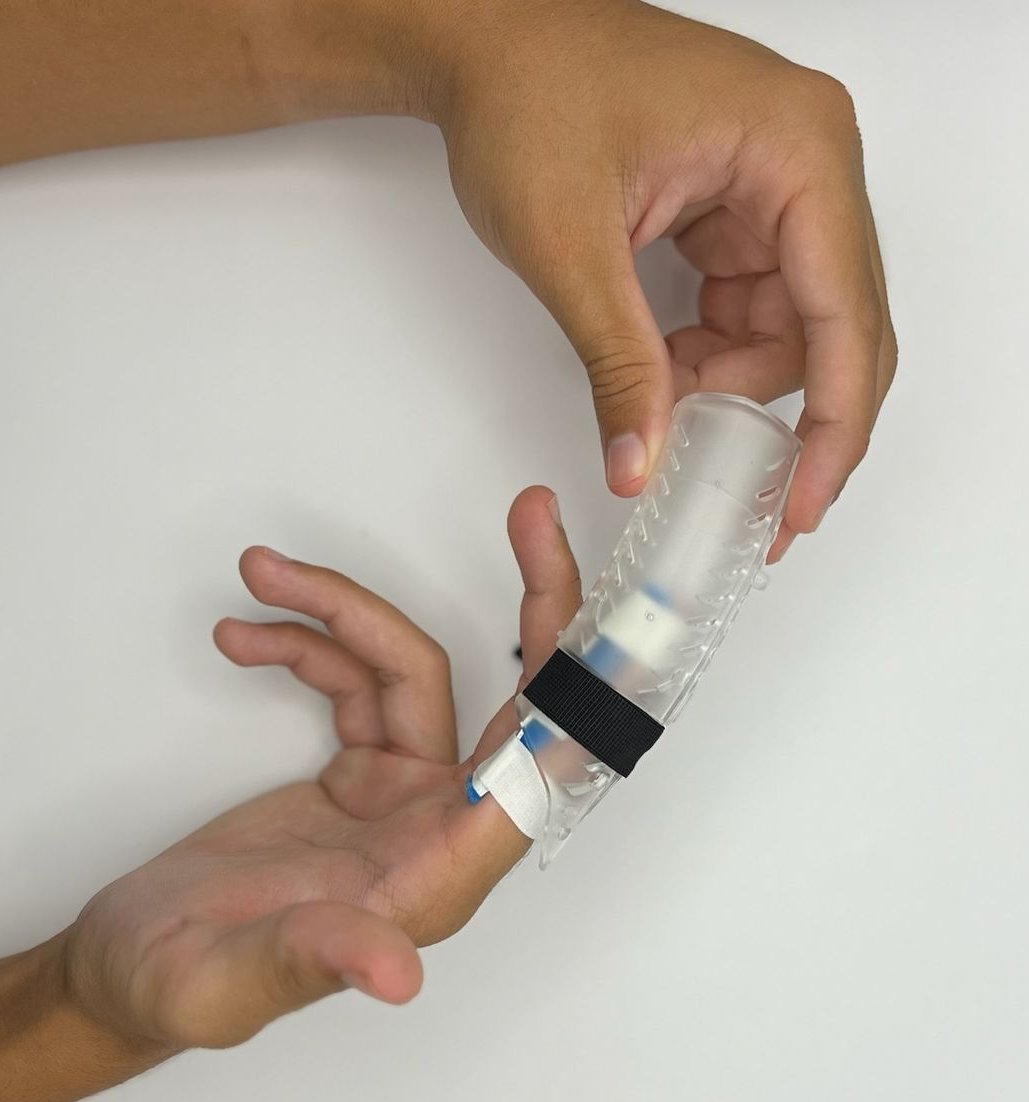 Hands adjusting a clear DigiTube finger splint with black tape on a white surface