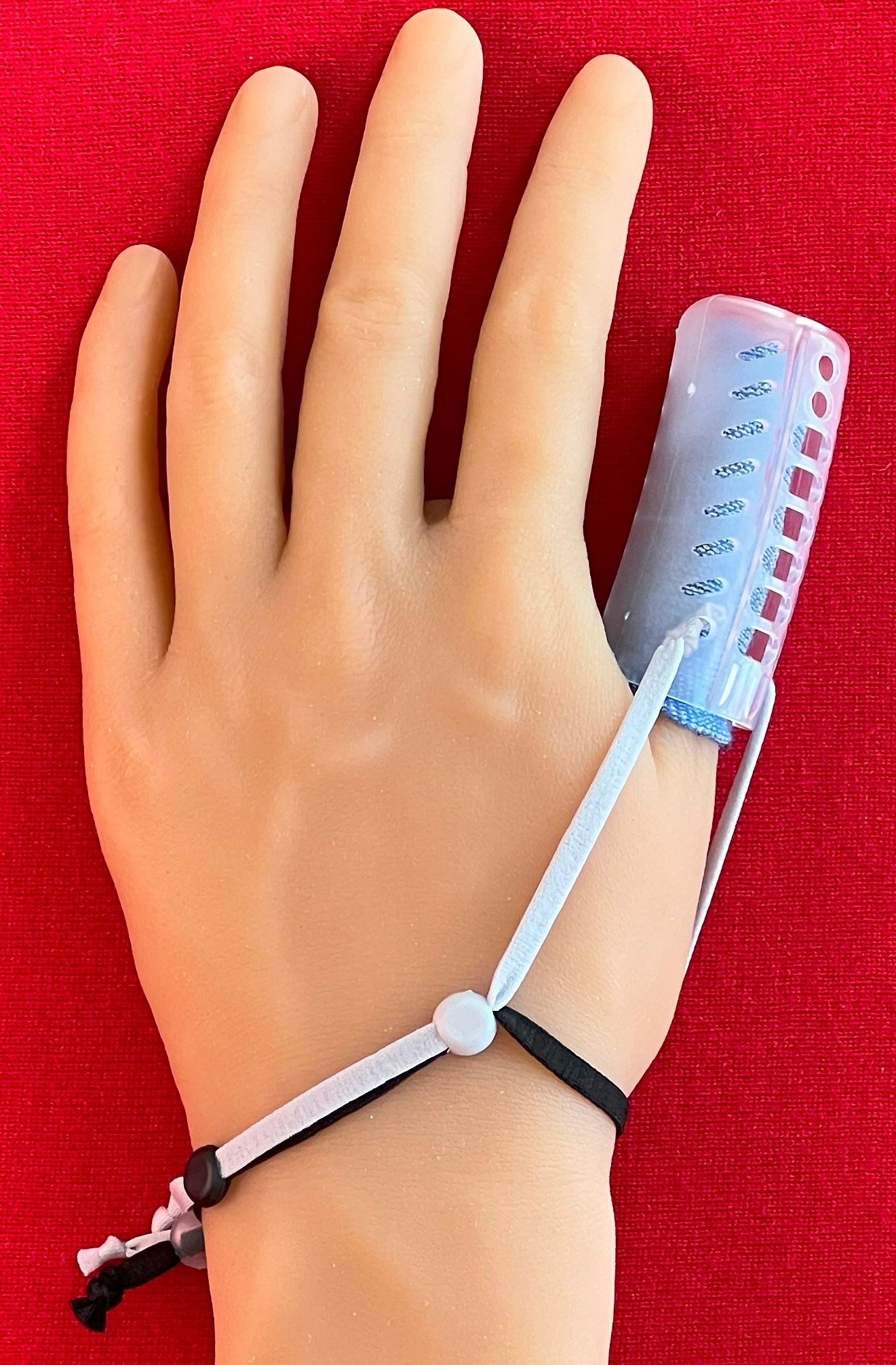 Hand with a DigiTube blue finger splint on a red background