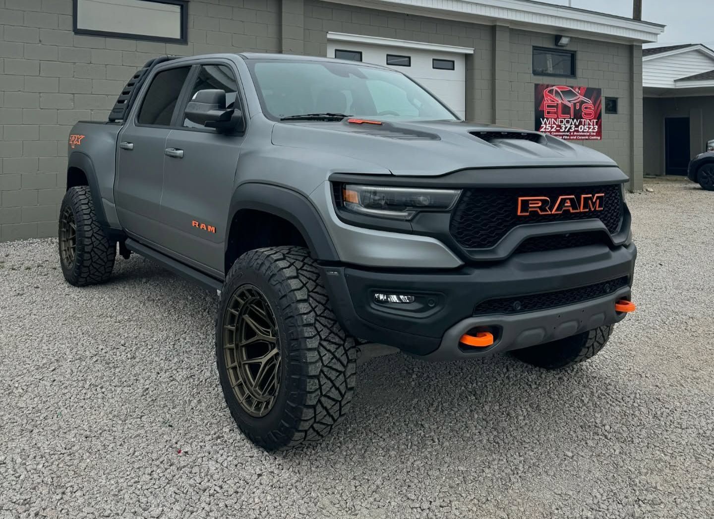 Gray Ram TRX truck with orange accents parked in front of a building.
