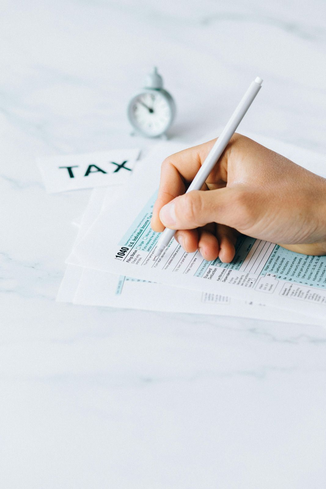 Hand filling out tax form;