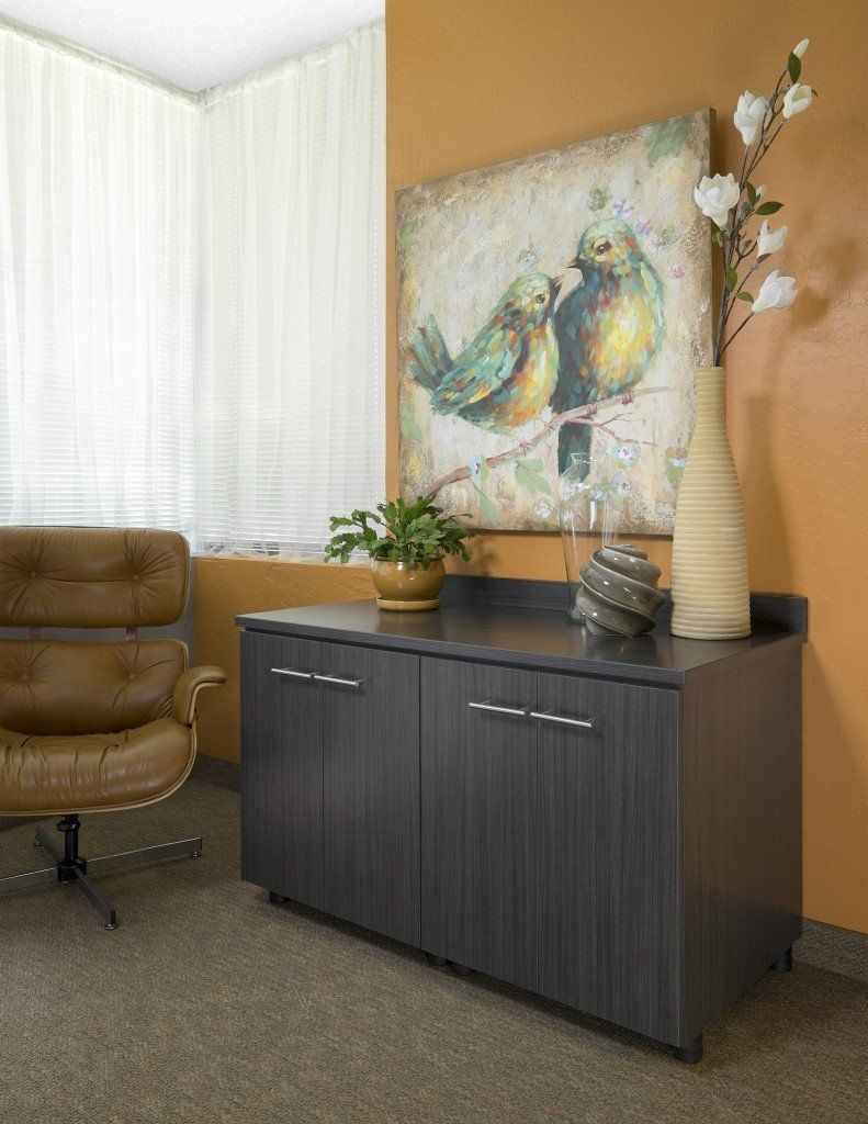 a home office credenza with flower vases on top