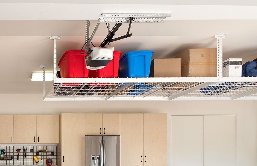 A garage with a ceiling rack filled with boxes and a lift.