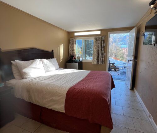 A hotel room with a bed and a window