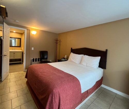 A hotel room with a king size bed and a bathroom