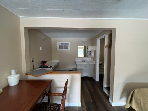 A room with a desk and chair and a sink