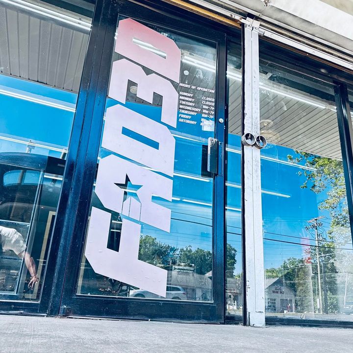 FedEx storefront window with large white and pink logo on blue-tinted glass