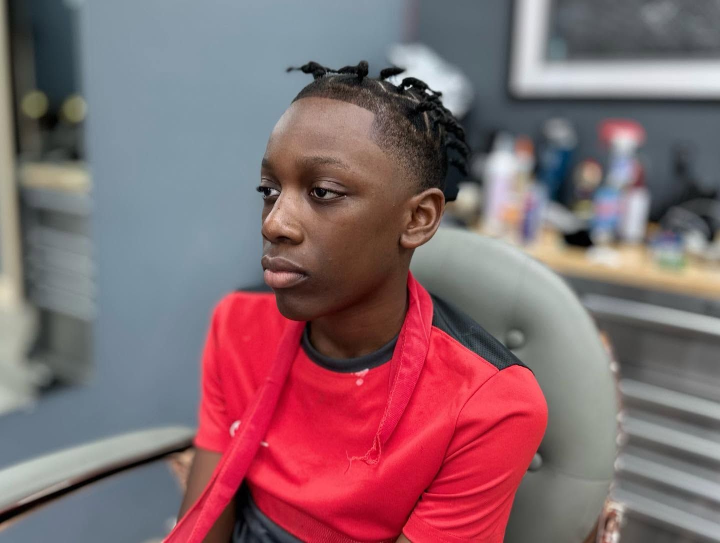 Person in a red shirt sitting in a chair, looking to the side in an office setting