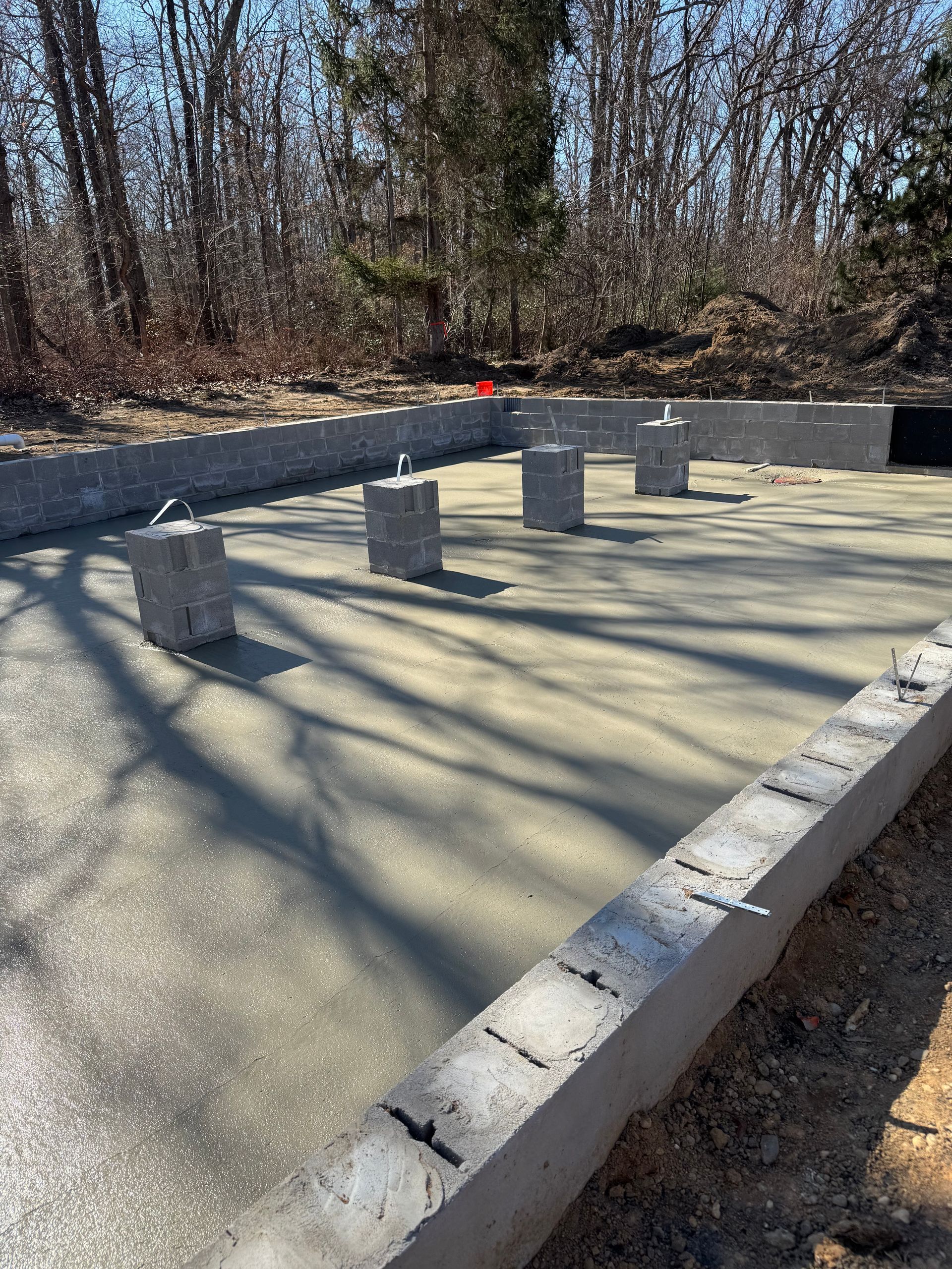 A concrete base for a house is being built in the woods.