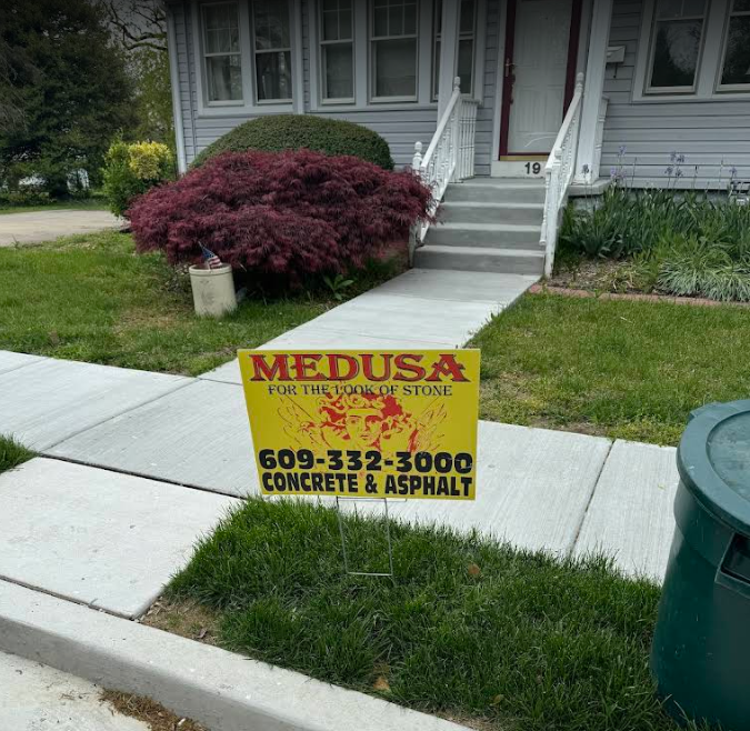 A medusa concrete and asphalt sign in front of a house
