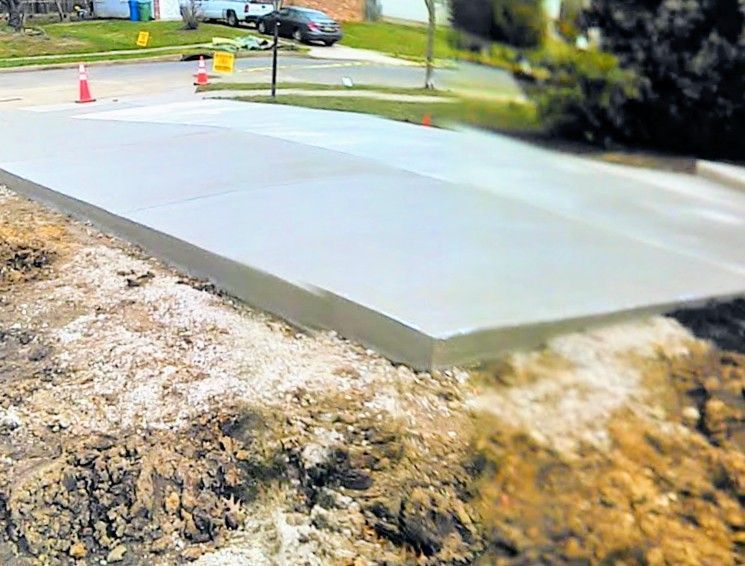 Freshly poured concrete driveway in a suburban setting.
