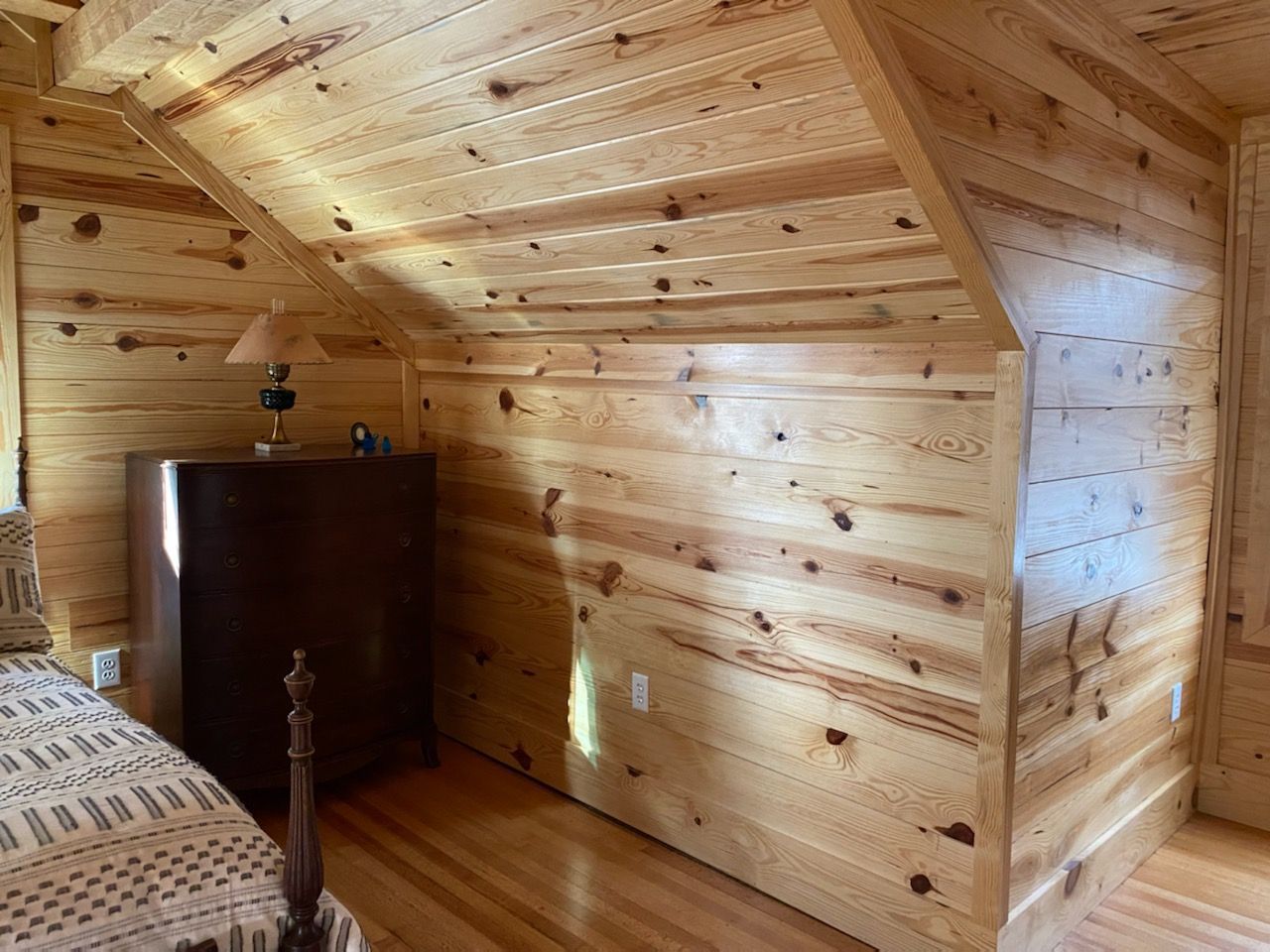 A bedroom in a cabin with wood paneling and a bed.