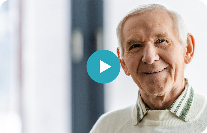 An elderly man is smiling for the camera