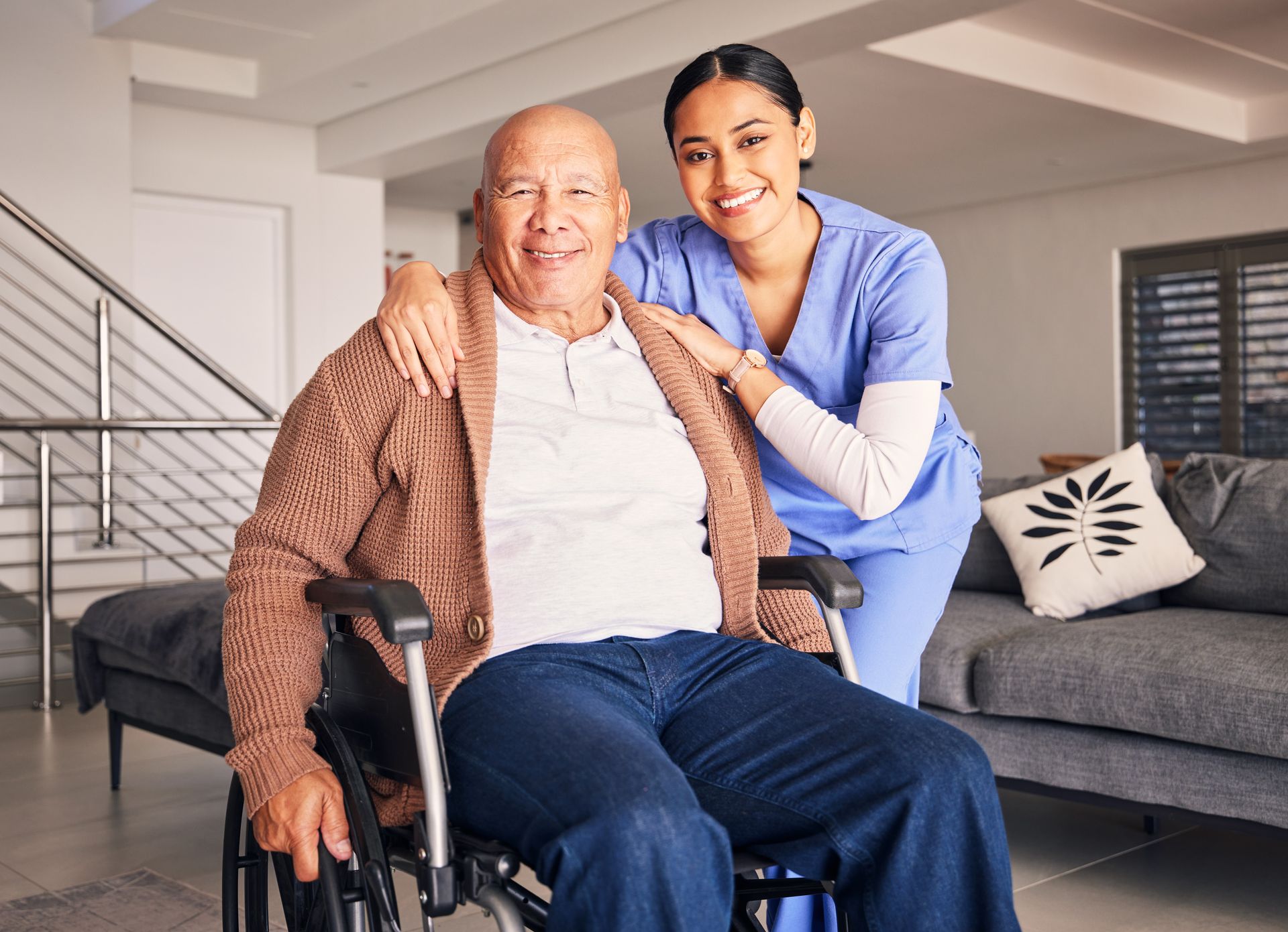 A nurse is standing next to an elderly man in a wheelchair.