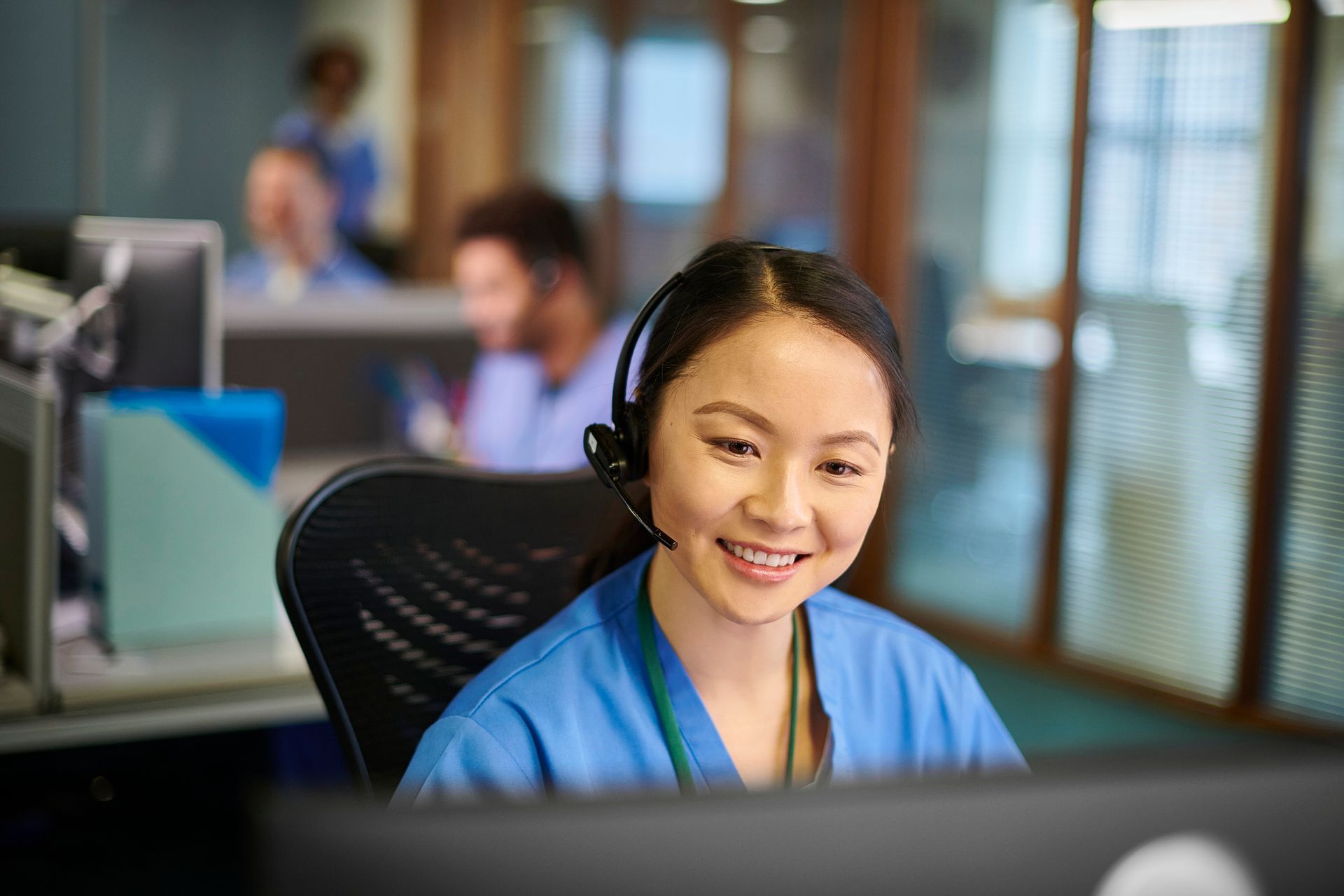 Nurse at INS LifeGuard 24/7 personal alarm monitoring wearing headset at desk in the response centre