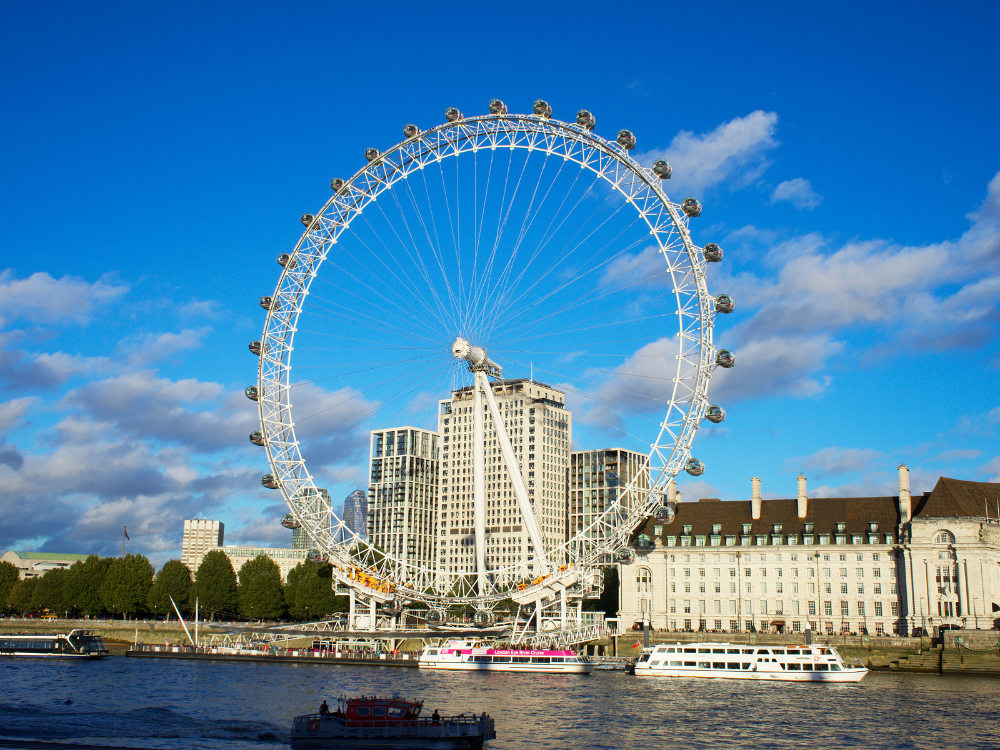 A large ferris wheel is sitting on top of a body of water.