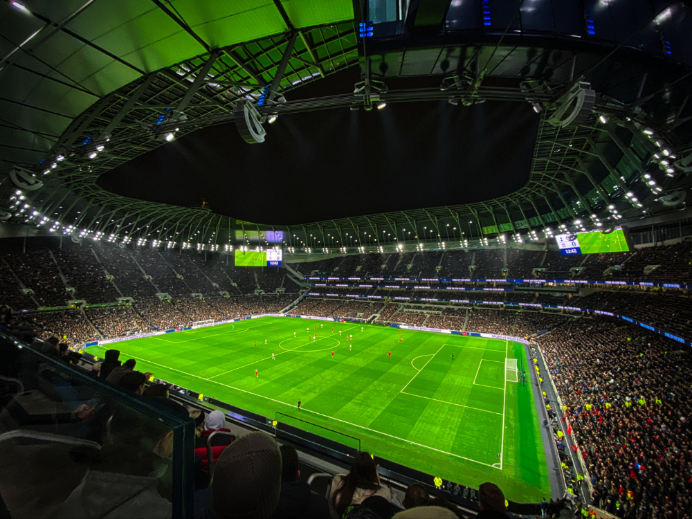 A soccer stadium filled with people watching a game.