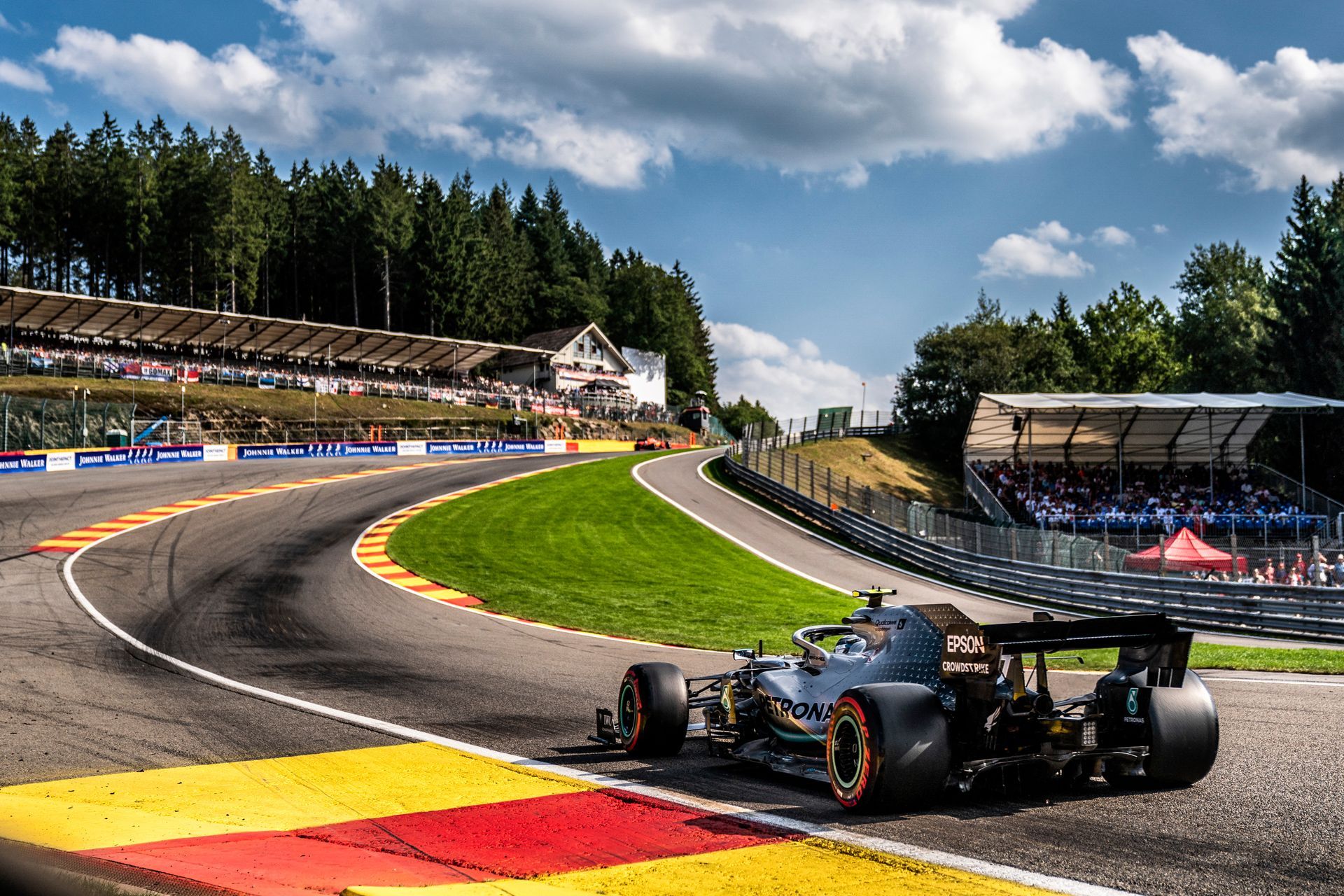 A race car is driving down a curvy race track.