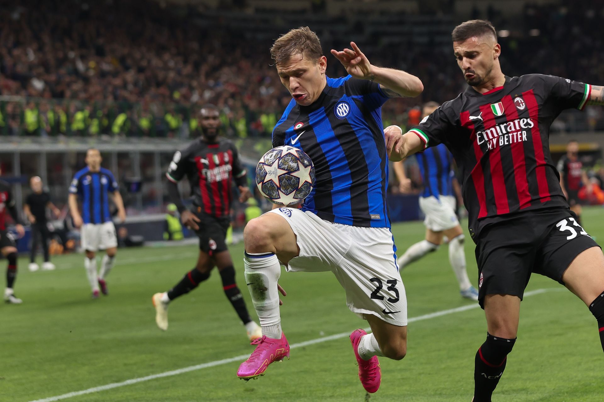 Two soccer players are fighting for the ball on a field.