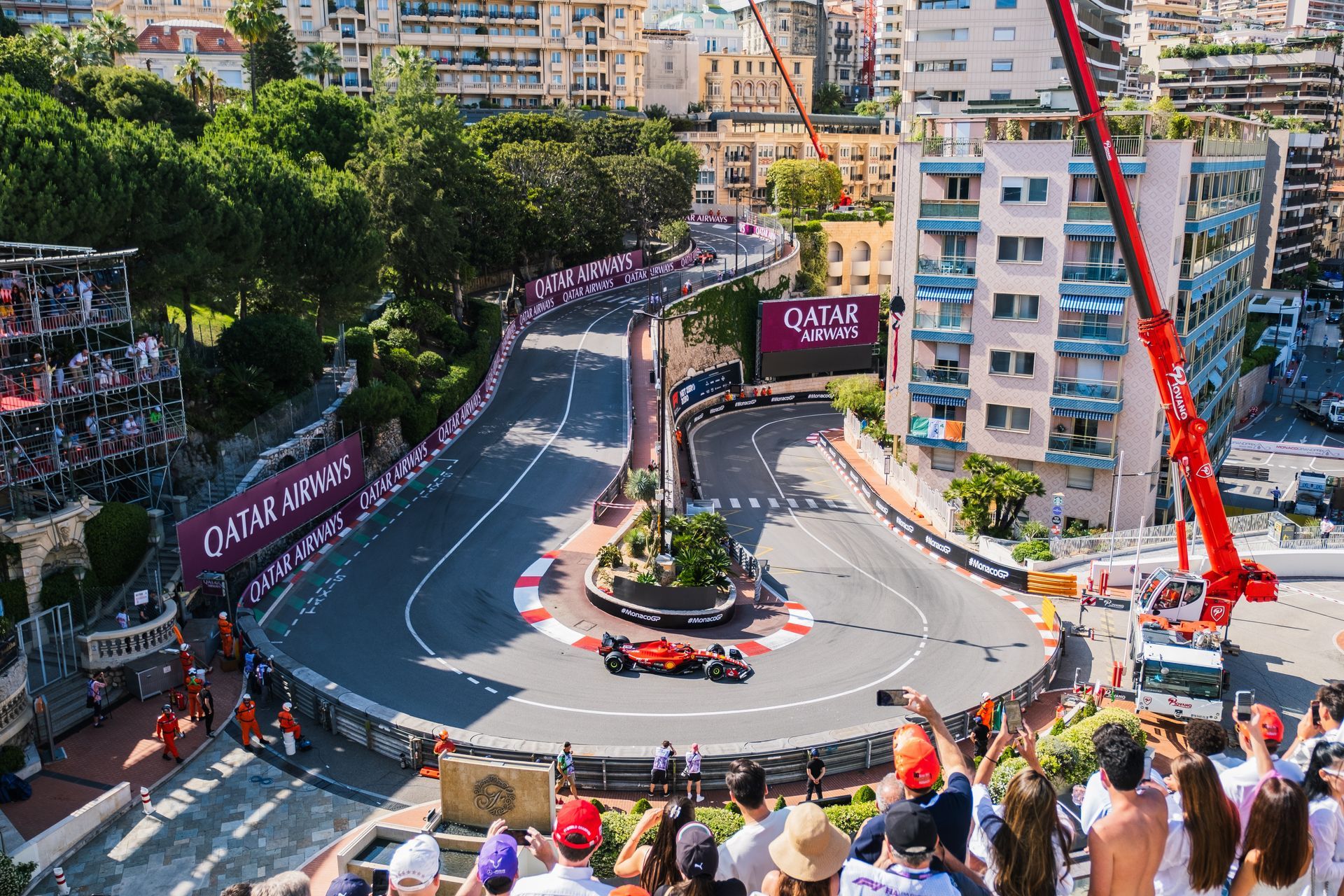 A group of people are watching a race on a track.
