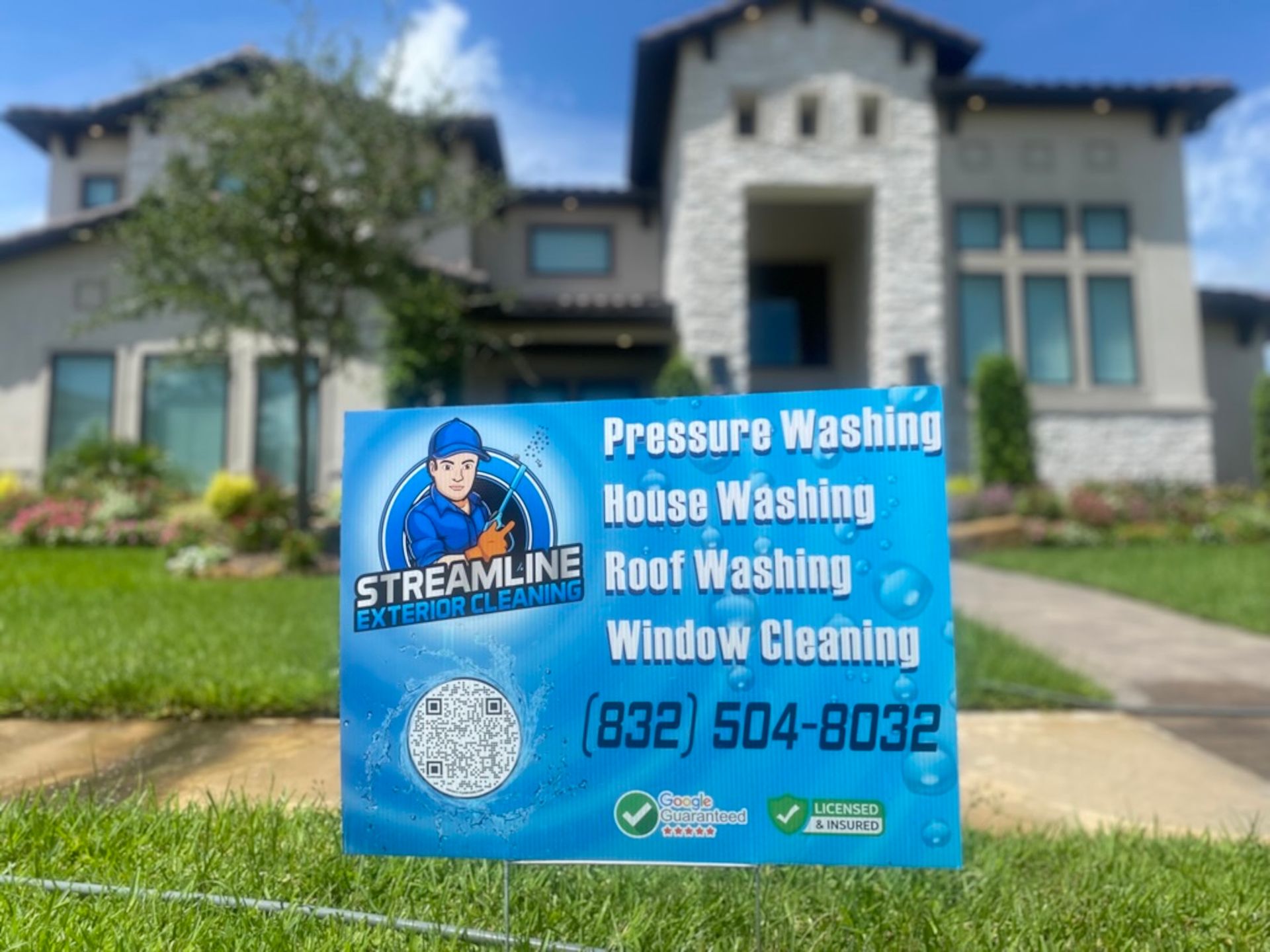 Blue Streamline pressure washing lawn sign in front of a house listing washing and window cleaning services.