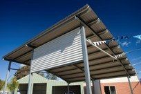 A garage with a metal roof and a clothes line underneath it.