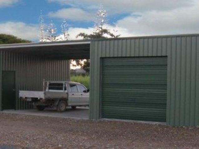 A truck is parked under a canopy in a garage.