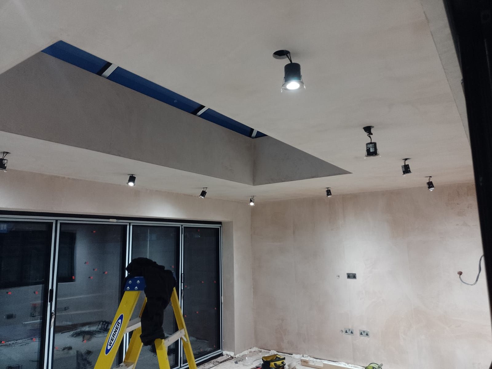 Downlights being installed in an extension with large ceiling window