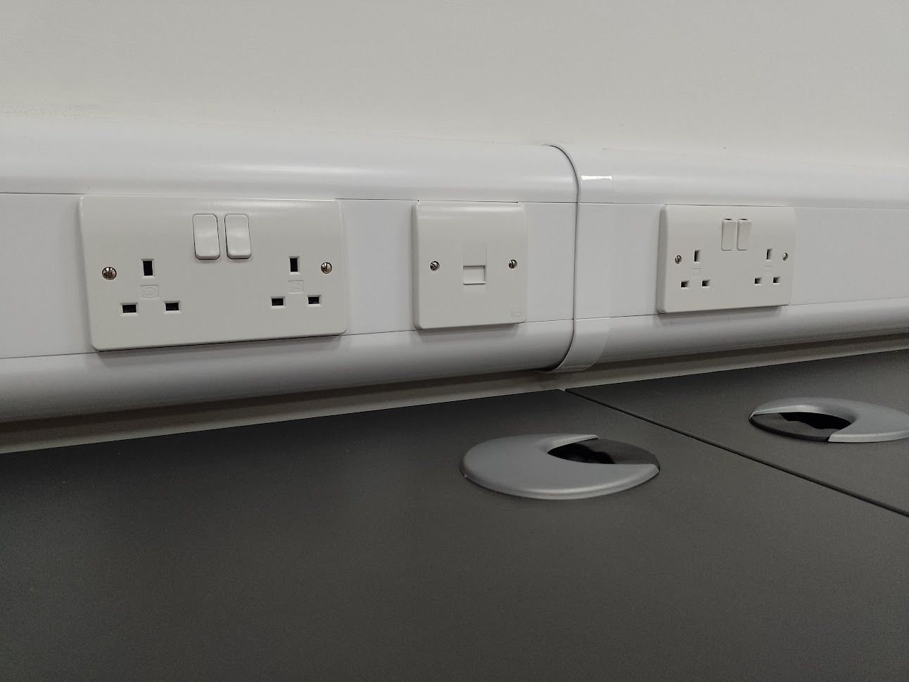 Office sockets mounted within trunking system next to data access point