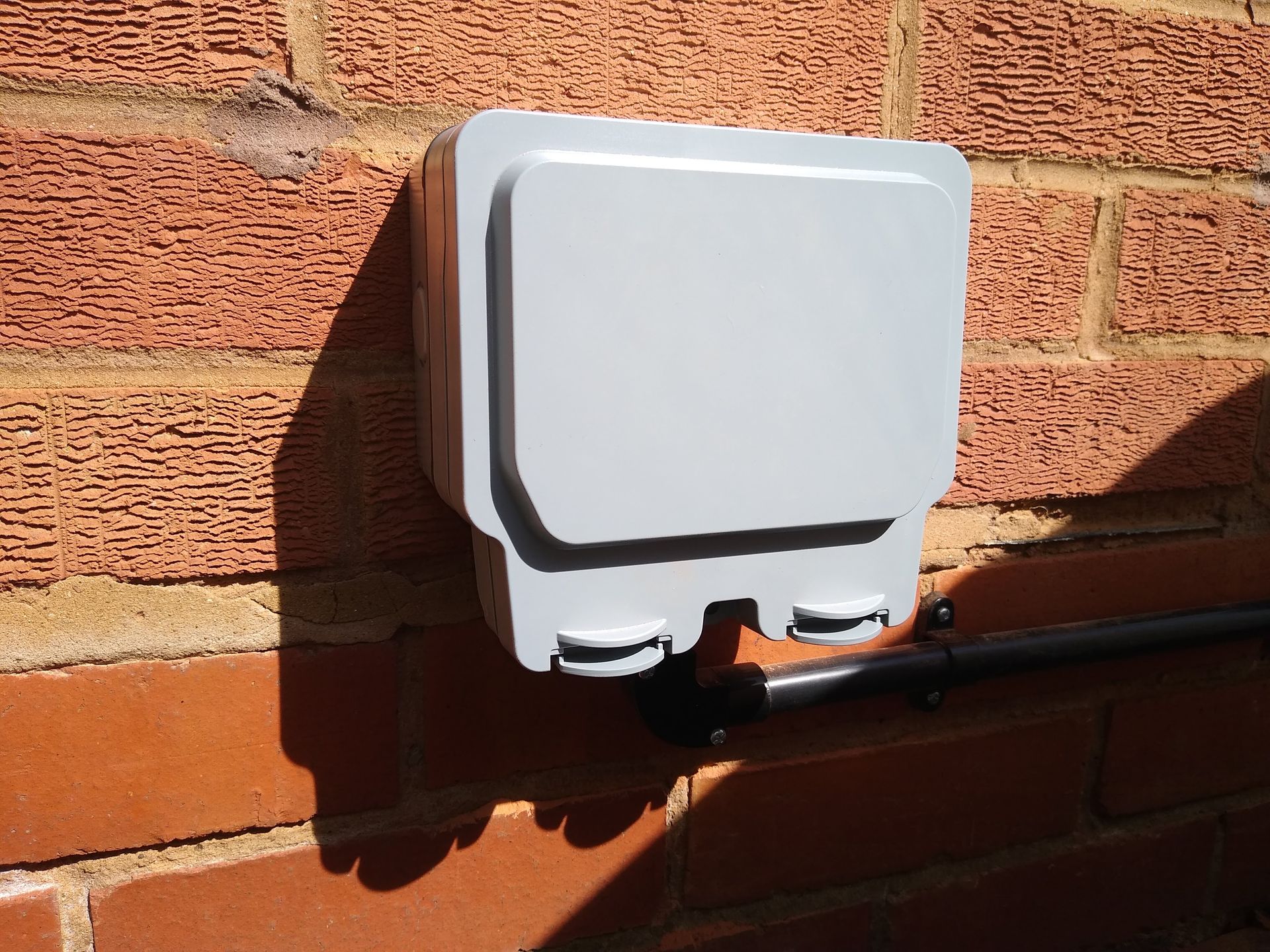 Outside IP65 socket installed supplied by black conduit from underside