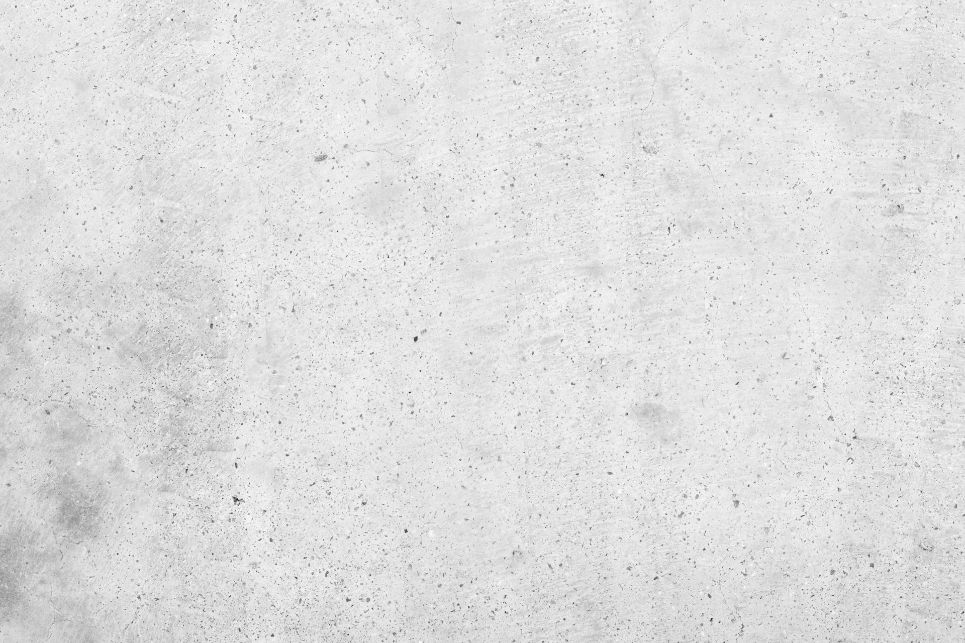 Light gray speckled concrete surface with subtle texture and small dark flecks