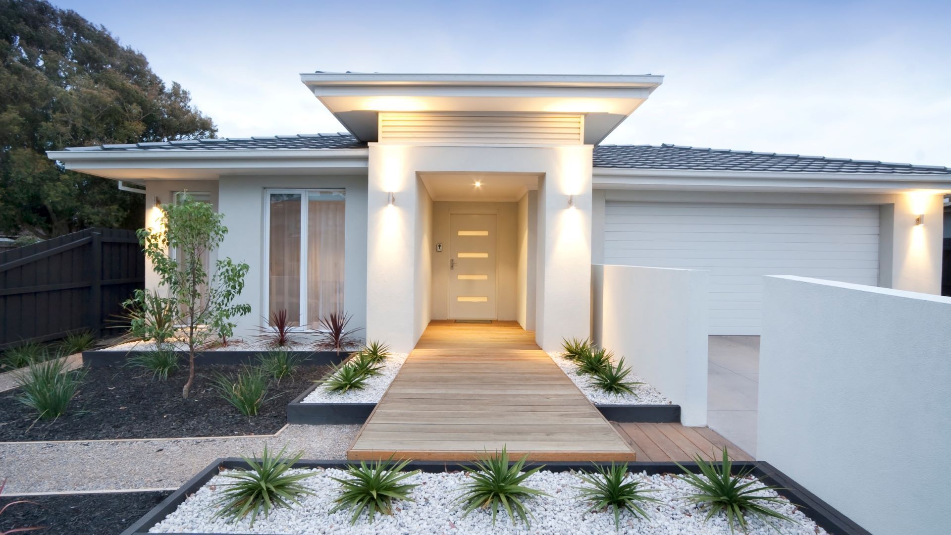 A white house with a wooden walkway leading to the front door.