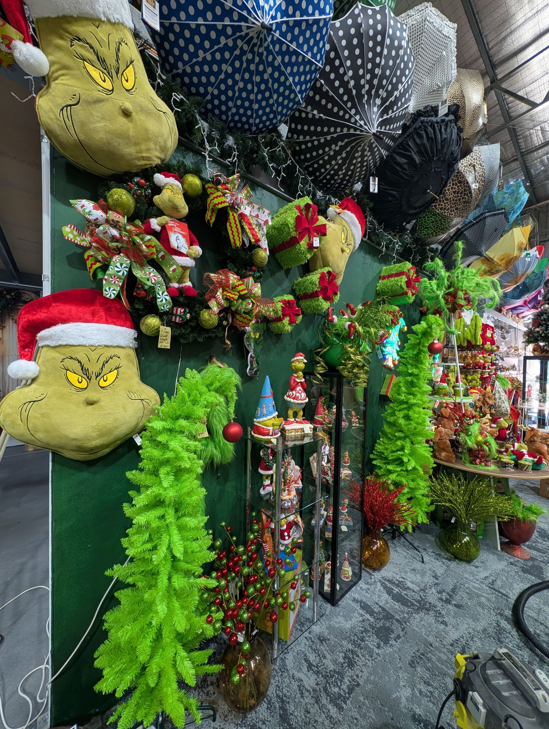 Festive hanging plant display with colorful flowers, greenery, and holiday gnome decorations outside a shop