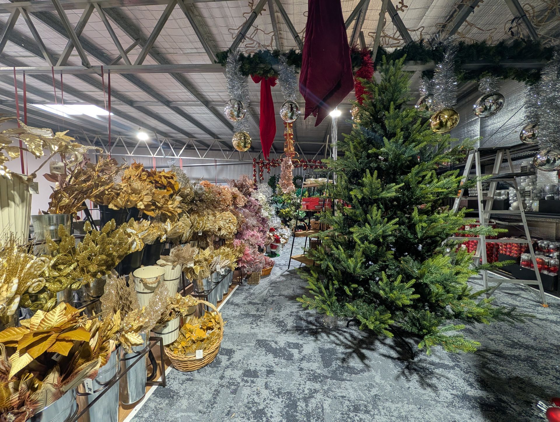 Store Aisle with Artificial Christmas Trees and Gold Holiday Wreaths — Jingle Bell Christmas In Casino, NSW