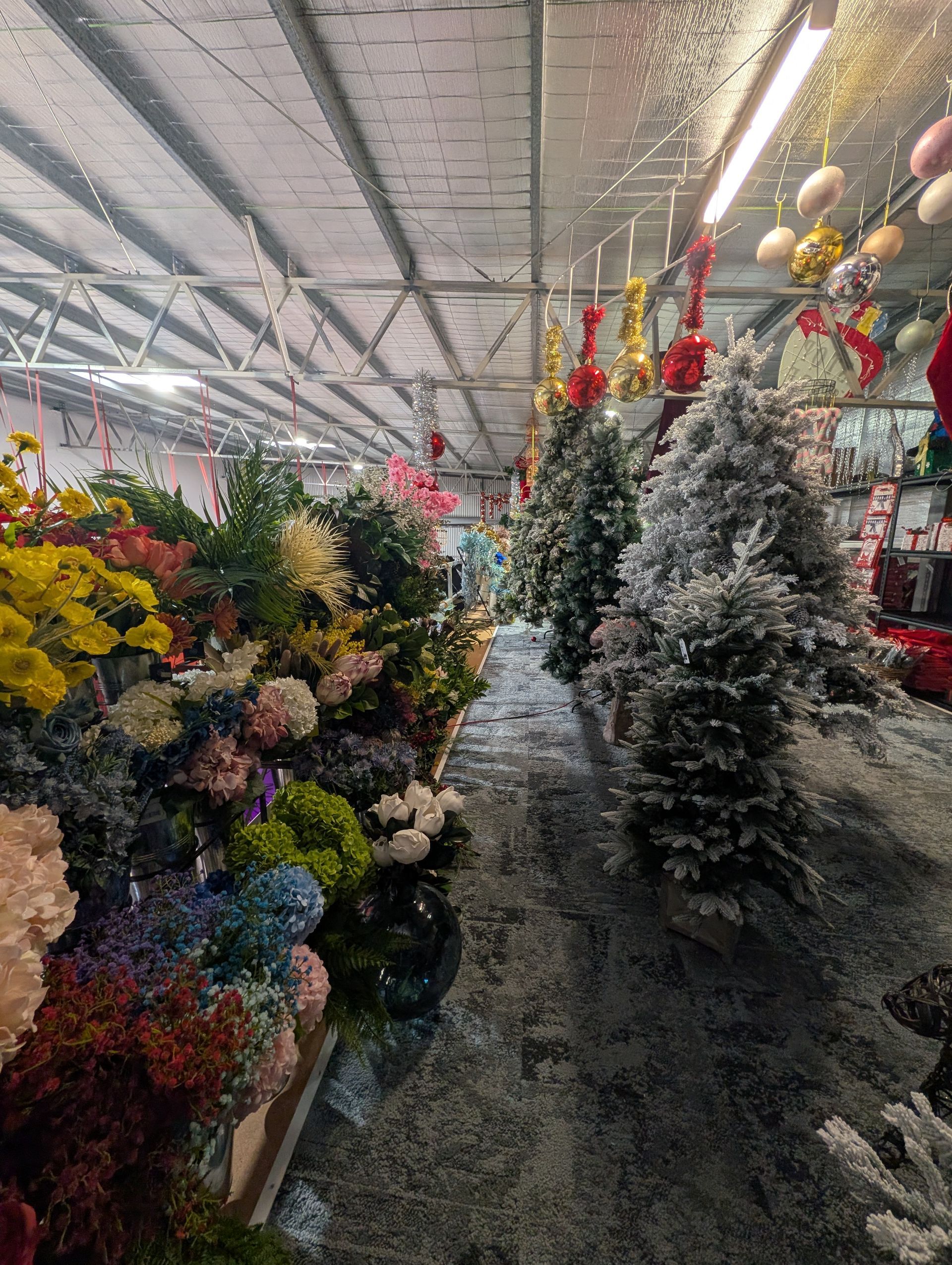 Aisle of Artificial Christmas Trees and Holiday Decorations in A Store — Jingle Bell Christmas In Casino, NSW