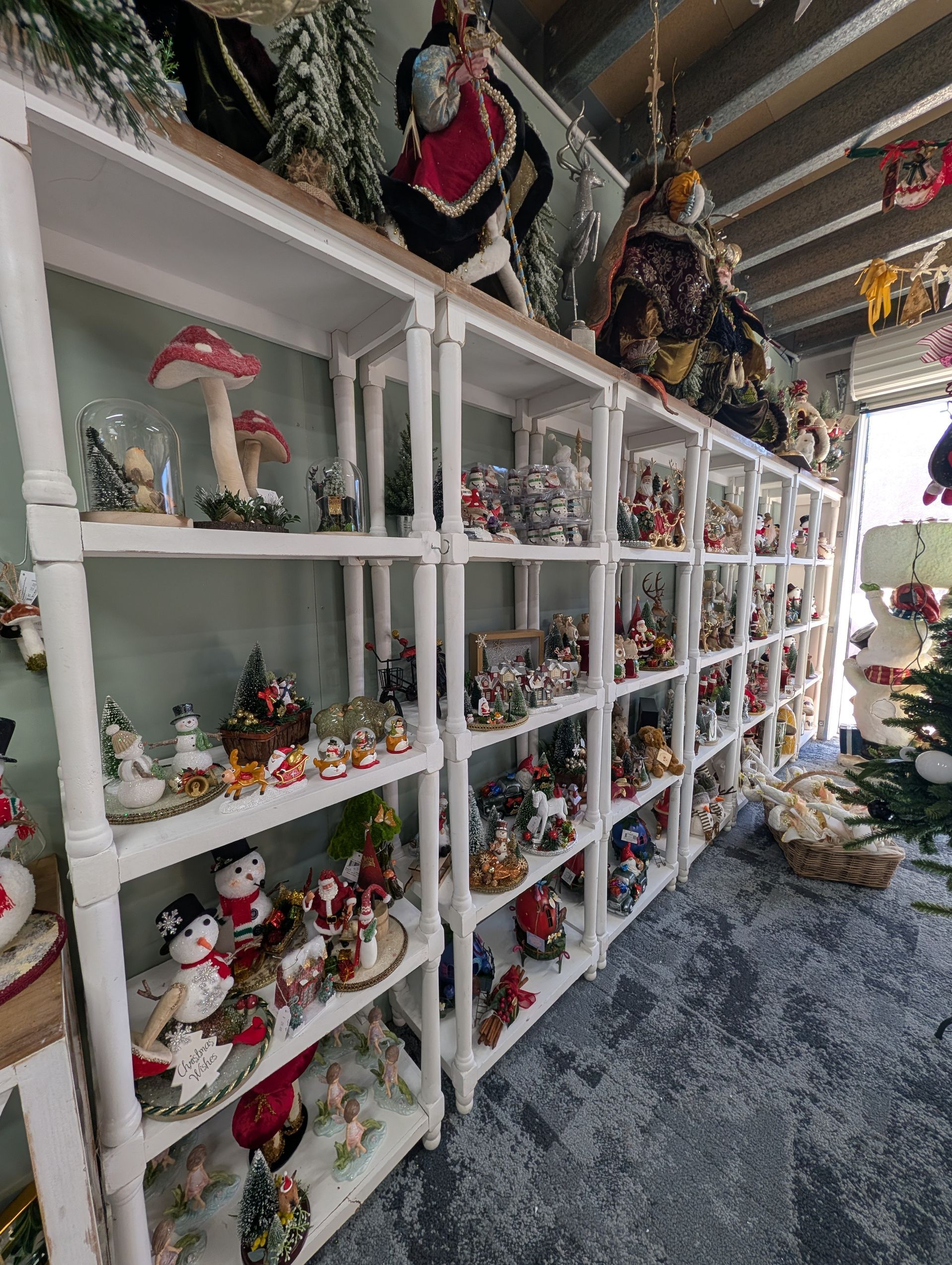 White Display Shelves Filled with Colorful Holiday Figurines — Jingle Bell Christmas In Casino, NSW