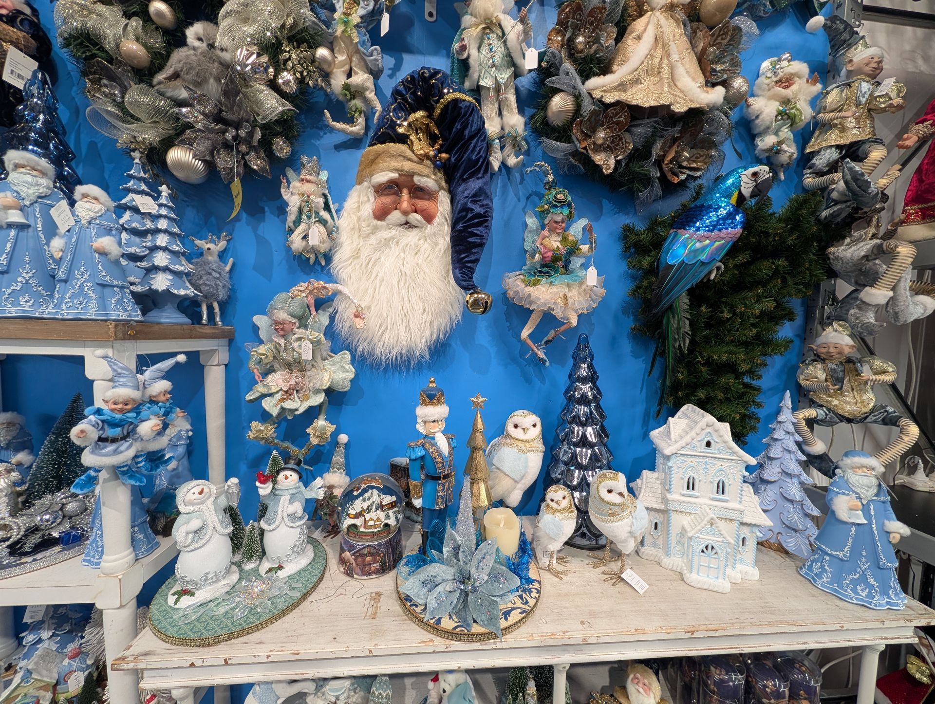 Festive holiday display with Santa figurine, snowmen, blue accents, and miniature winter village decorations