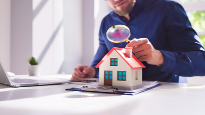 Tall, glass-walled office buildings against a vibrant blue sky with streaky white clouds.