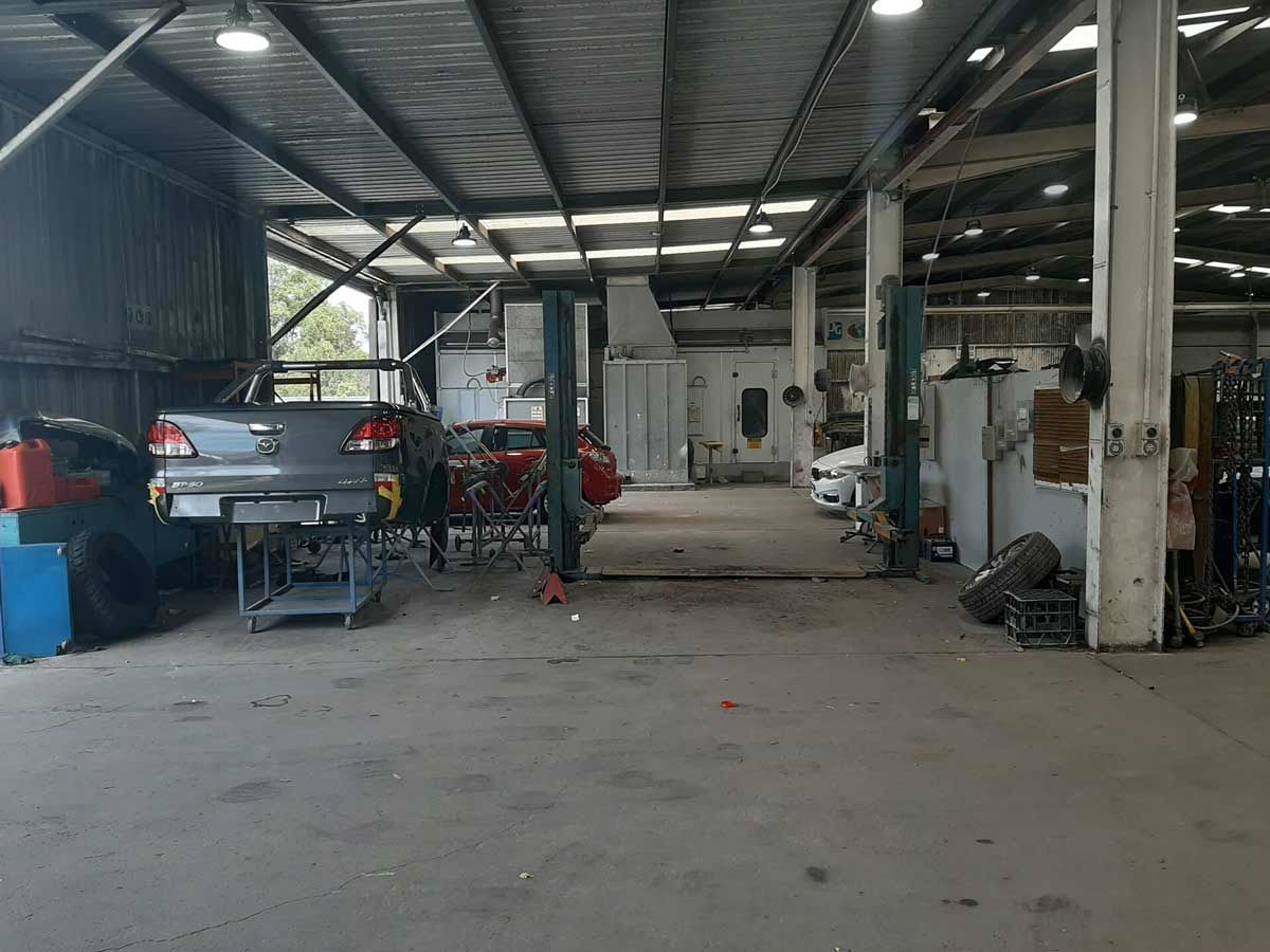 A Car is Sitting on a Lift in a Garage — Vanderpoel Smash Repairs in Tuggerah, NSW