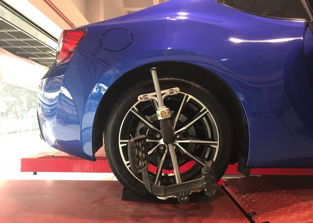 A Blue Car is Being Adjusted by a Machine in a Garage — Vanderpoel Smash Repairs in Gosford, NSW
