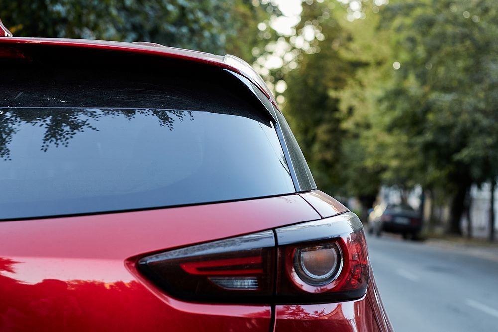 The Back of a Red Car is Parked on the Side of the Road — Vanderpoel Smash Repairs in Bateau Bay, NSW