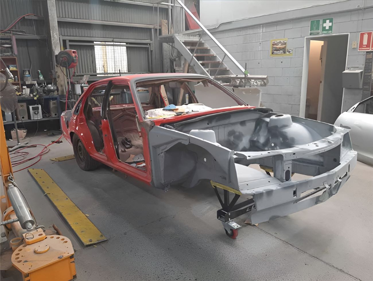 A Red Car is Being Built in a Garage — Vanderpoel Smash Repairs in Tuggerah, NSW