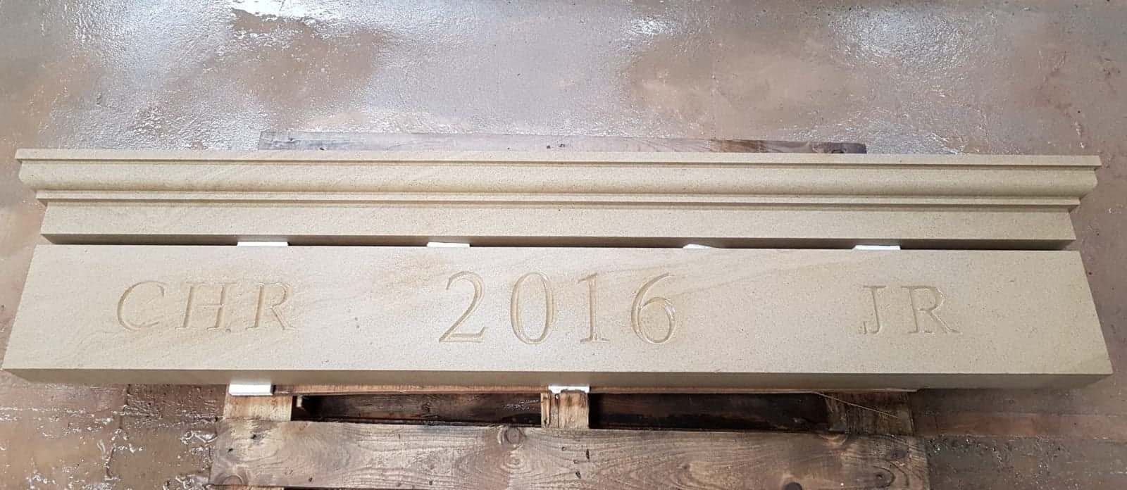 Stone bench engraved “2016” in a pale indoor setting.